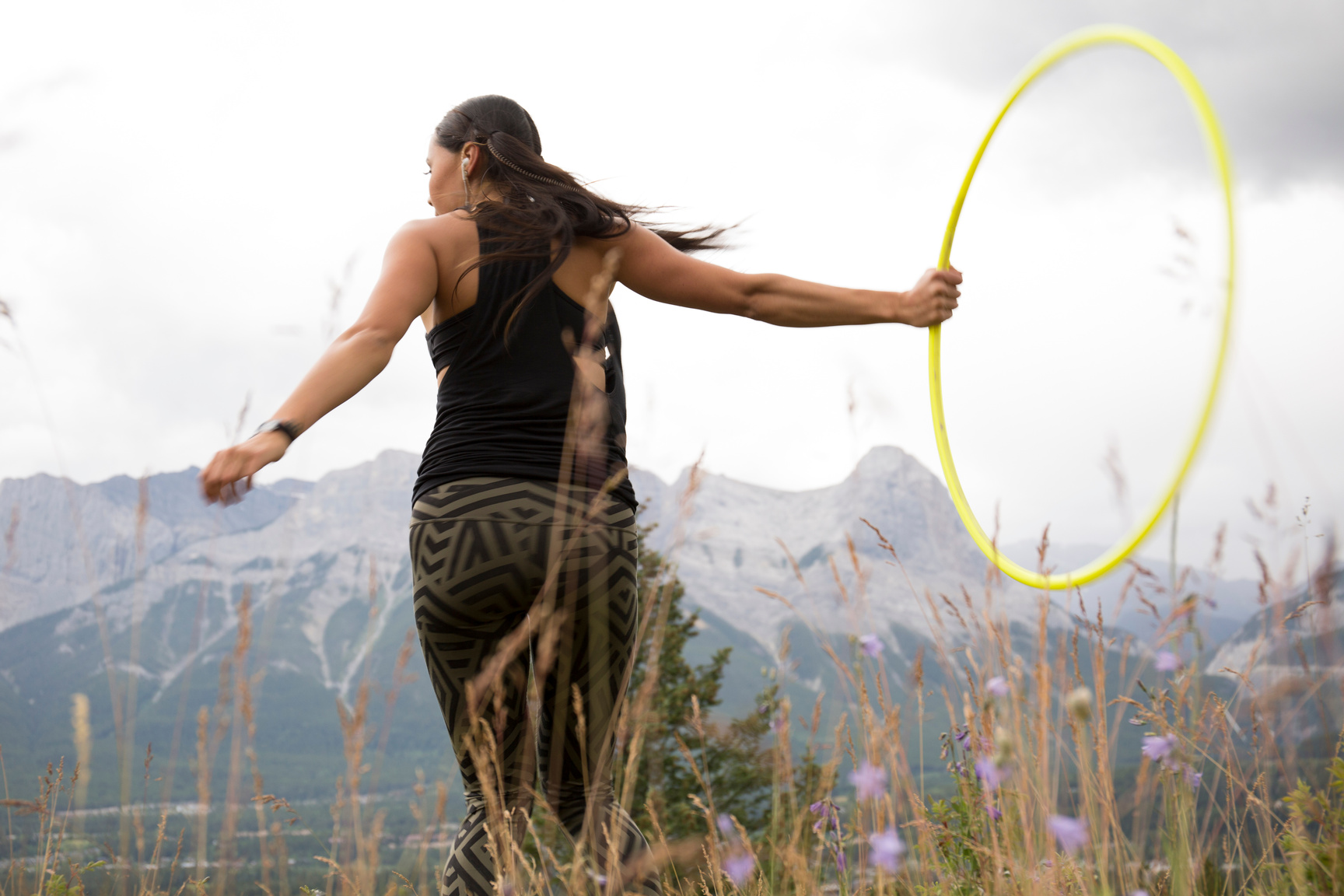 Native American woman dances with hoops, in mountains